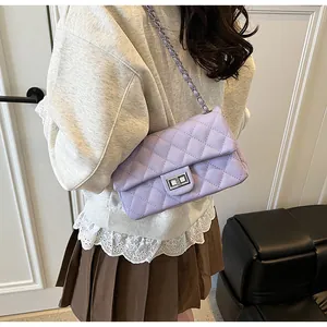 Detail showing lavender quilted crossbody bag with silver chain strap and metal clasp