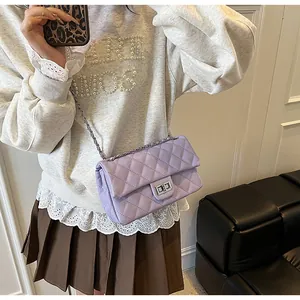 Close-up of lilac quilted crossbody bag with silver twist lock and chain strap on model