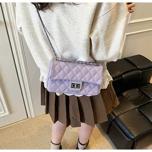Close-up of light purple quilted chain bag showing the texture and metal lock detail