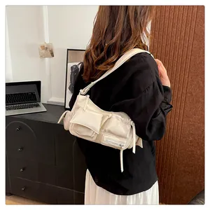 Detail of off-white multi-pocket shoulder bag in shiny oil wax leather finish