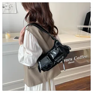 Detail of black glossy vintage shoulder bag with functional pockets in a cafe setting
