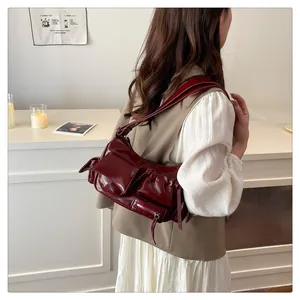 Close-up of vintage wine red motorcycle bag featuring multiple pockets and glossy finish