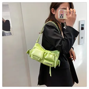 Detail of neon green moto shoulder bag featuring multi-pocket design and metallic zippers