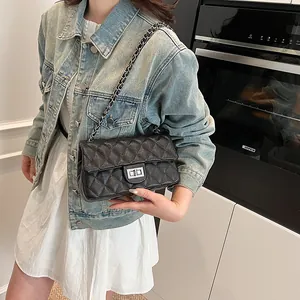 Classic black quilted crossbody bag with metal chain strap and turn-lock closure on model