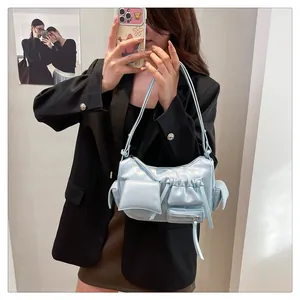 Detail of light blue oil wax leather bag with multi-pocket design and drawstring pockets