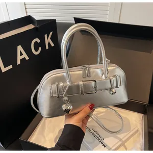 Détail du petit sac argenté métallisé avec boucle de ceinture et pendentif en cœur