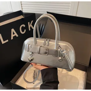 Détails du sac à main argenté métallisé avec breloque cœur et boucles décoratives