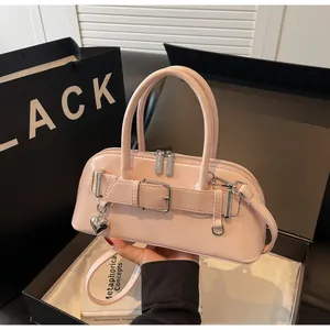 Détail d'un sac rose avec pendentif cœur et boucle dans un coffret cadeau