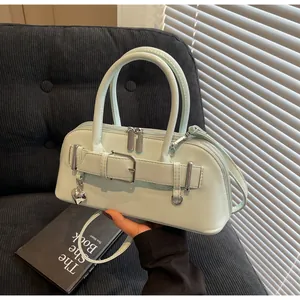 Détail du sac en cuir vert menthe avec boucle de ceinture et charm cœur argenté