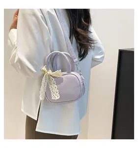 Detail of light purple crossbody bag featuring a delicate off-white lace bow decoration