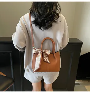 Sac seau en cuir marron avec foulard en soie tournesol, vue arrière portée par un mannequin