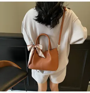 Sac seau en cuir marron avec foulard en soie à carreaux et bandoulière réglable chic