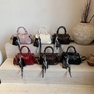 Minimalist bowling style handbags in six colors with embossed lettering and charms