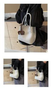 Detail of white lychee pattern leather bucket bag with cute brown elephant charm