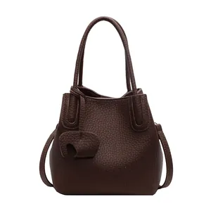 Close-up of deep brown lychee texture leather with a decorative elephant charm