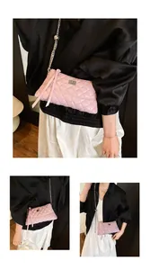 Détail du sac à chaîne matelassé rose avec fermoir rotatif argenté et pompon latéral