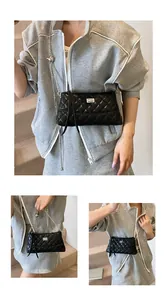 Détail du sac bandoulière noir matelassé avec chaîne argentée et boule de réglage