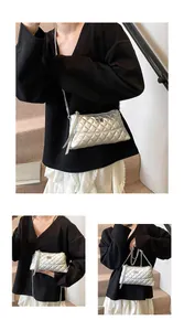 Détail du sac argenté matelassé avec bandoulière en chaîne et fermoir de luxe