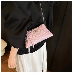 Détail du sac à bandoulière matelassé rose avec fermoir rotatif argenté et pompons