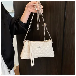 Détail du sac matelassé blanc crème avec chaîne argentée et fermoir pivotant
