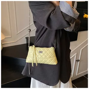 Détails du sac à bandoulière matelassé jaune clair avec chaîne argentée et glands