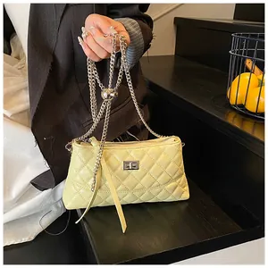 Gros plan détaillé du sac matelassé jaune avec boucle argentée et bandoulière en chaîne