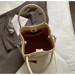 Interior detail of creamy white bucket bag with lychee texture and magnetic closure