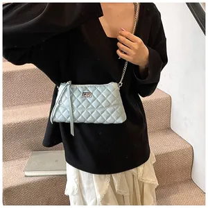 Gros plan d'un sac à bandoulière matelassé bleu clair avec chaîne et fermoir tournant