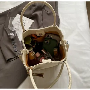 Spacious interior of off-white pebble leather bucket bag showing storage for essentials