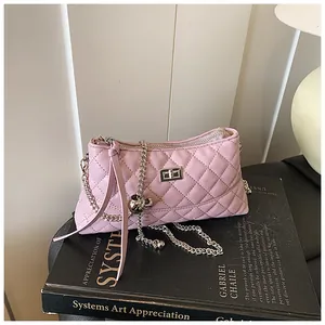 Vue détaillée du sac matelassé rose avec chaîne argentée et boule métallique