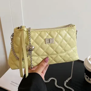 Sac matelassé chic jaune crème avec breloque boule en métal et longues franges