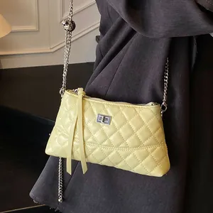 Petit sac bandoulière jaune matelassé avec chaîne argentée et finition vernie brillante