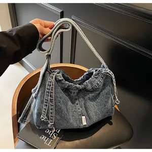Vue détaillée d'un sac cabas en denim avec cordon de serrage et étiquette OIIL BAG