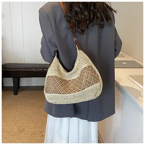 Detail of hand-woven straw shoulder bag with hollow mesh design and leather straps