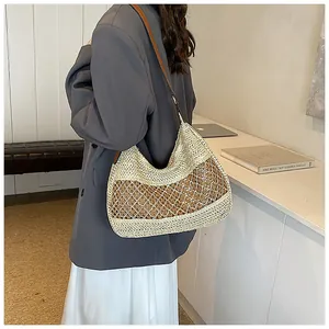 Detail of a large capacity straw bag with two-tone weave and wavy openwork texture