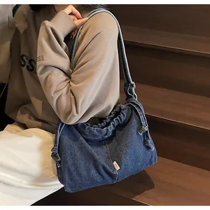Vue détaillée du sac cabas en denim bleu foncé avec cordon de serrage et étiquette vintage