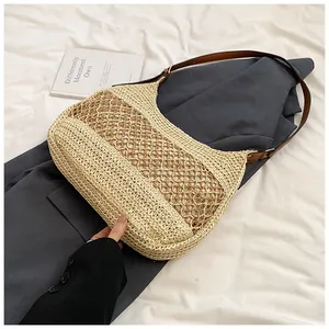 Detail of straw woven bag featuring large mesh hollow design and brown leather strap