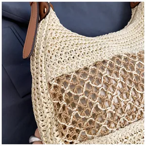 Detail of woven straw beach bag with grid pattern and premium brown leather handle