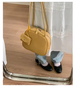Dettaglio della borsa tote gialla in pelle martellata con mini portamonete e tracolla sottile