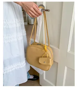 Dettaglio della borsa tote in pelle martellata giallo zenzero con zip argentata