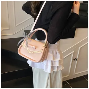 Close-up of pink square handbag with beige lace edges and a mini decorative bow detail