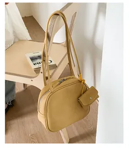 Dettaglio della borsa tote giallo zenzero con mini pochette coordinata su una sedia