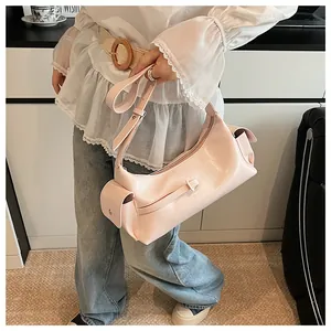 Détail du sac à main en cuir verni rose clair avec poches latérales et bandoulière