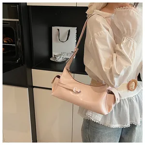 Gros plan d'un sac sous le bras rose clair brillant avec bandoulière réglable sur modèle