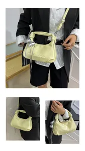 Détail du sac dumpling en cuir jaune clair avec lettres en relief et pendentifs nœud
