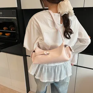 Sac baguette rose avec fermetures éclair décoratives et poches latérales porté par un mannequin