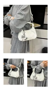 Détails de la surface blanche brillante et du pendentif nœud argenté du sac