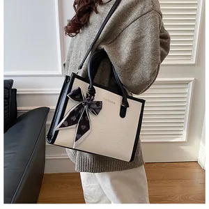 Détail du sac cabas bicolore avec poignée en foulard de soie et bandoulière amovible