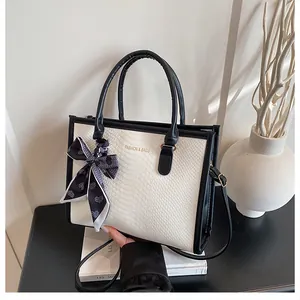 Détail du sac bicolore avec cuir motif serpent et foulard en soie à imprimé cœur
