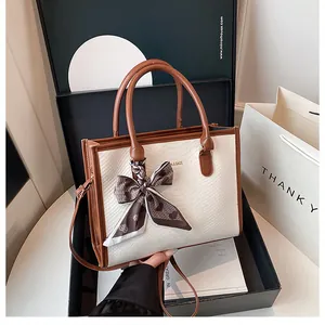 Détail du sac à main blanc motif serpent avec foulard en soie et logo N & BAGS
